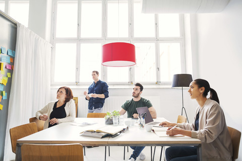 Team of business people listening to presentation in meeting room stock photo