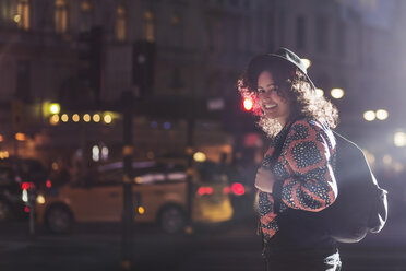 Seitenansicht Porträt der lächelnden Frau auf der Straße in der Stadt bei Nacht stehen - MASF03950