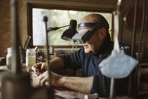 Älterer Handwerker bei der Arbeit in der Werkstatt - MASF03984