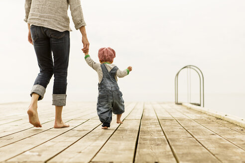 Rückansicht einer Mutter, die mit ihren Töchtern auf dem Pier spazieren geht, gegen einen klaren Himmel - MASF04008