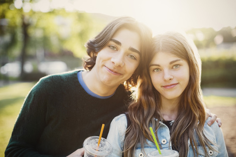 Portrait of smiling teenagers at park on sunny day stock photo