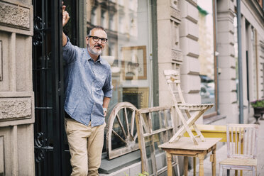 Portrait of owner standing with hand on hip at antique shop - MASF04105