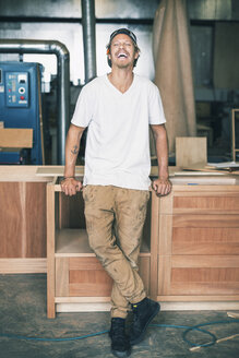 Portrait of carpenter laughing while standing at workshop - MASF04119