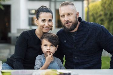 Porträt einer glücklichen Familie, die zusammen im Garten sitzt - MASF04120