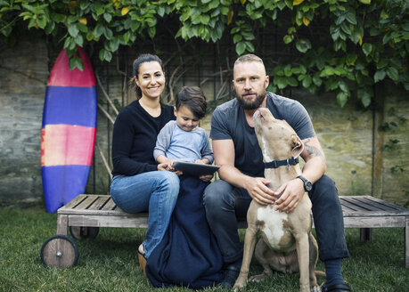 Porträt einer Familie mit Hund im Garten sitzend - MASF04121