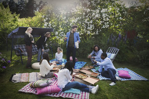 Multiethnische Freunde bei einem Sommerfest im Hof mit Snacks - MASF04135