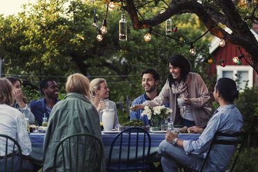 Multiethnische Freunde genießen ein Abendessen im Garten - MASF04140