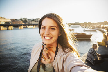 Portrait of happy female tourist by river in city - MASF04148