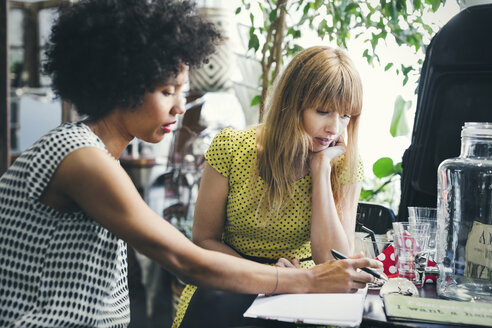 Mid adult female workers discussing in interior design shop - MASF04164