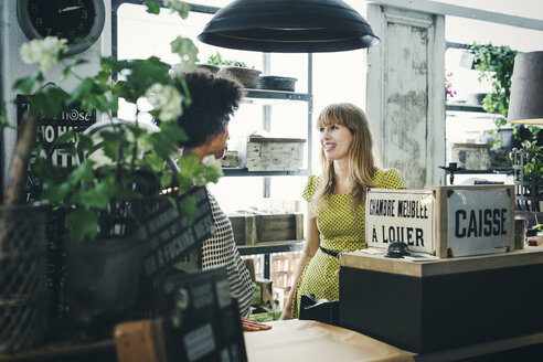 Mid adult female workers communicating in store - MASF04165