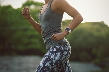 Midsection of woman running at park - MASF04174