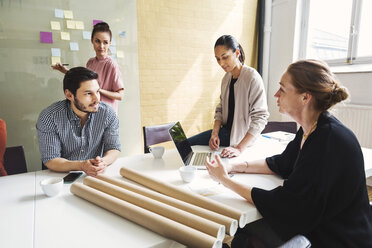 Mature businesswoman discussing with colleagues at conference table - MASF04182