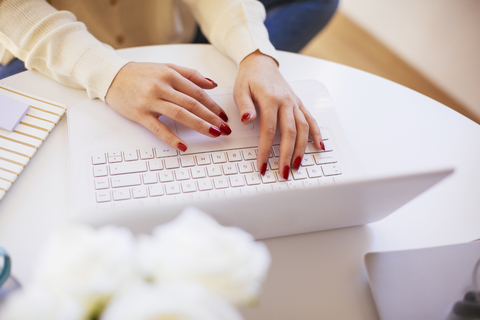 Frau benutzt Laptop zu Hause, lizenzfreies Stockfoto