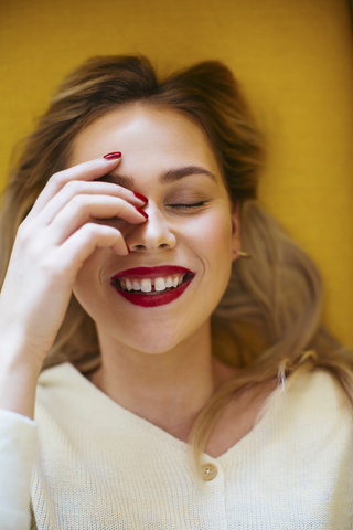 Lächelnde blonde Frau auf Sofa liegend, lizenzfreies Stockfoto