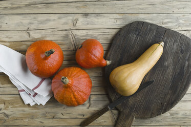 Roter Hokkaido, Cucurbita maxima, und Butternusskürbis, Cucurbita moschata, auf Holz - ASF06172