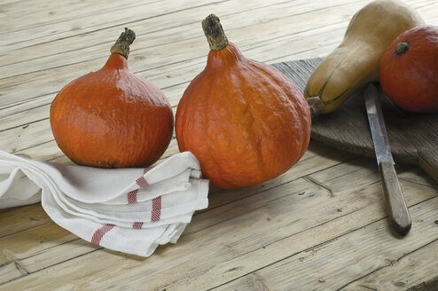 Roter Hokkaido, Cucurbita maxima, und Butternusskürbis, Cucurbita moschata, auf Holz - ASF06173