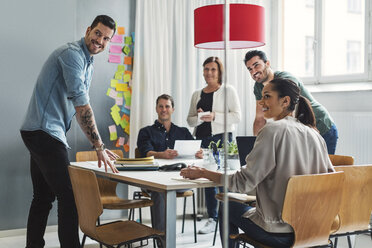 Glückliches Team von Geschäftsleuten, die ein Projekt am Tisch im Büro besprechen - MASF04244