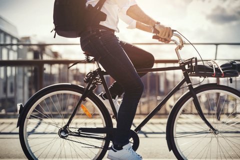 Tiefschnitt eines Geschäftsmannes beim Fahrradfahren auf einer Brücke, lizenzfreies Stockfoto