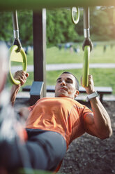 Man hanging with rings and doing chin-ups - MASF04297