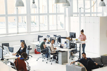 Blick von oben auf multiethnische Geschäftsleute, die in einem modernen Büro arbeiten - MASF04306