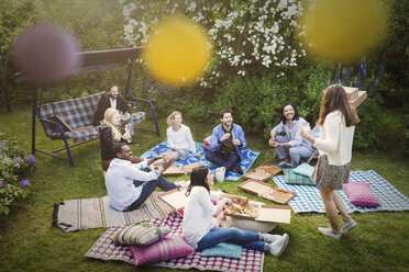 Hohe Winkel Ansicht von Freunden mit Snacks während der Sommer-Party im Hof - MASF04317