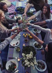High angle view of multi-ethnic friends toasting drinks at dinner table in yard - MASF04319