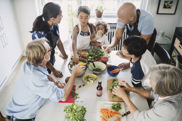 High angle view of family preparing Asian food at table - MASF04326