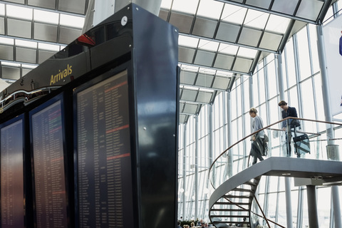 Niedriger Blickwinkel auf Geschäftskollegen, die eine Treppe im Flughafen hinuntergehen, lizenzfreies Stockfoto