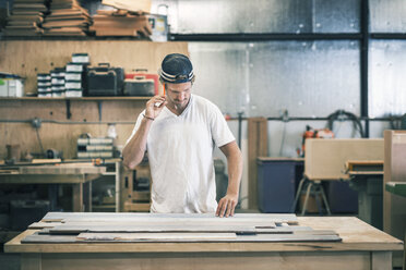 Carpenter working at workbench in workshop - MASF04354
