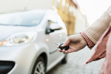 Cropped image of businesswoman using remote control key to unlock car - MASF04364