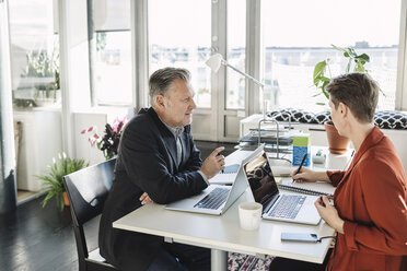 Businessman having discussion with colleague at desk - MASF04483