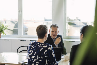 Geschäftsleute, die am Tisch im Büro diskutieren - MASF04490