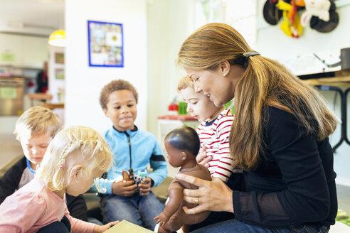 Erzieherin und Kinder mit Spielzeug im Kindergarten - MASF04533