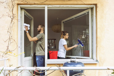 Woman and man cleaning window together - MASF04592