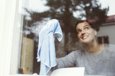 Woman cleaning glass of house window - MASF04593