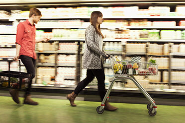 Junges Paar geht im Supermarkt an den Regalen vorbei - MASF04597