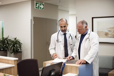 Ärzte besprechen medizinische Berichte, während sie im Krankenhaus stehen - CAVF38481