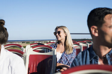 Touristen, die in einem Doppeldeckerbus gegen einen strahlend blauen Himmel fahren - CAVF38519