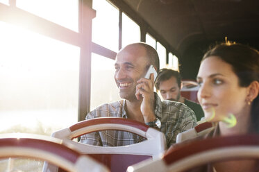 Mann, der in einem Reisebus mit einem Mobiltelefon spricht - CAVF38528