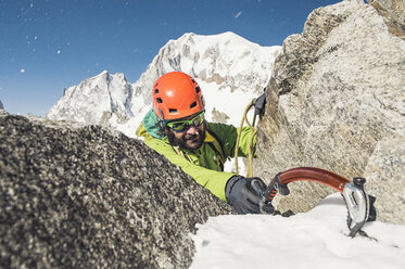 Männlicher Wanderer beim Bergsteigen im Winter - CAVF38537