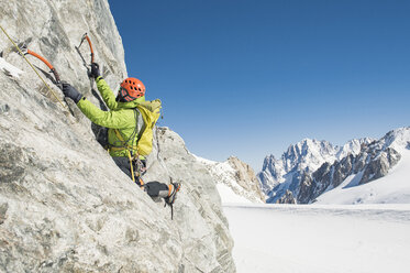 Männlicher Wanderer beim Bergsteigen gegen einen klaren blauen Himmel im Winter - CAVF38542