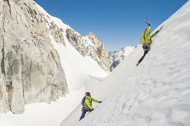 Wanderer klettern schneebedeckten Berg gegen klaren blauen Himmel während sonnigen Tag - CAVF38547