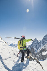 Seitenansicht eines Wanderers mit Skiern, der auf einem schneebedeckten Berg steht, gegen einen klaren blauen Himmel an einem sonnigen Tag - CAVF38561