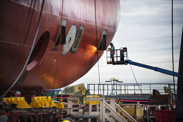 Worker repairing container ship at industry - CAVF38578