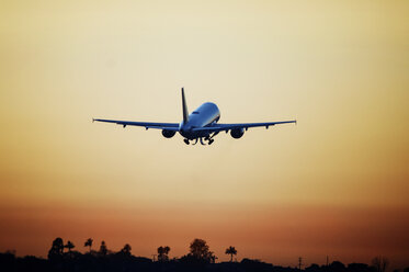 Niedrigen Winkel Ansicht des Flugzeugs fliegen gegen den Himmel bei Sonnenuntergang - CAVF38615