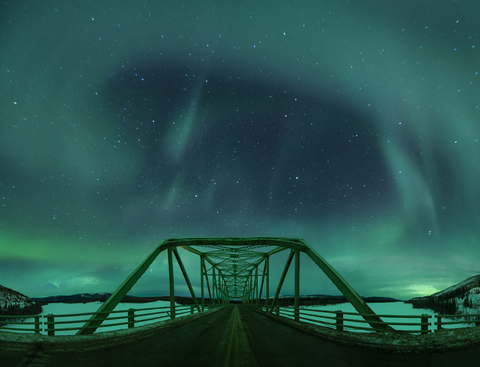 Majestätischer Blick auf Polarlichter über die Alaska Highway Bridge, lizenzfreies Stockfoto