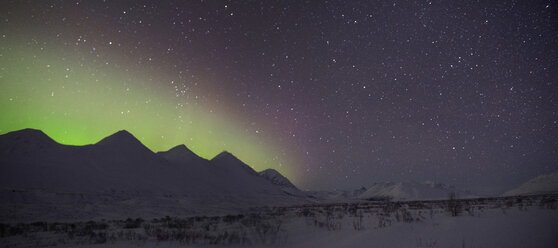 Scenic view of snowcapped mountains against aurora borealis - CAVF38653