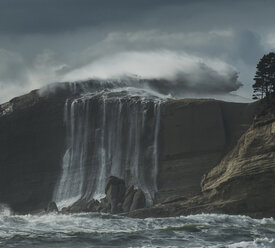 Low angle view of waterfall against stormy clouds at Cape Kiwanda State Park - CAVF38699