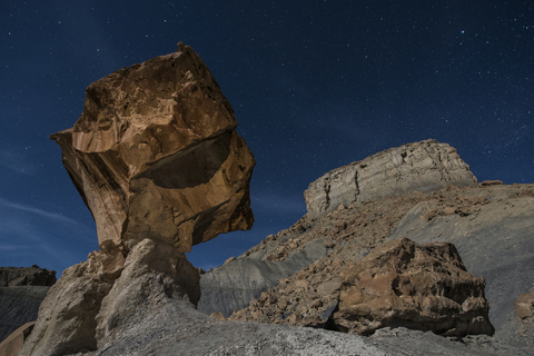 Low angle view of rock formations against star field at Grand Staircase-Escalante National Monument stock photo