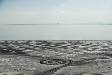 High angle view of spiral pattern on sand by Great Salt Lake against sky - CAVF38783